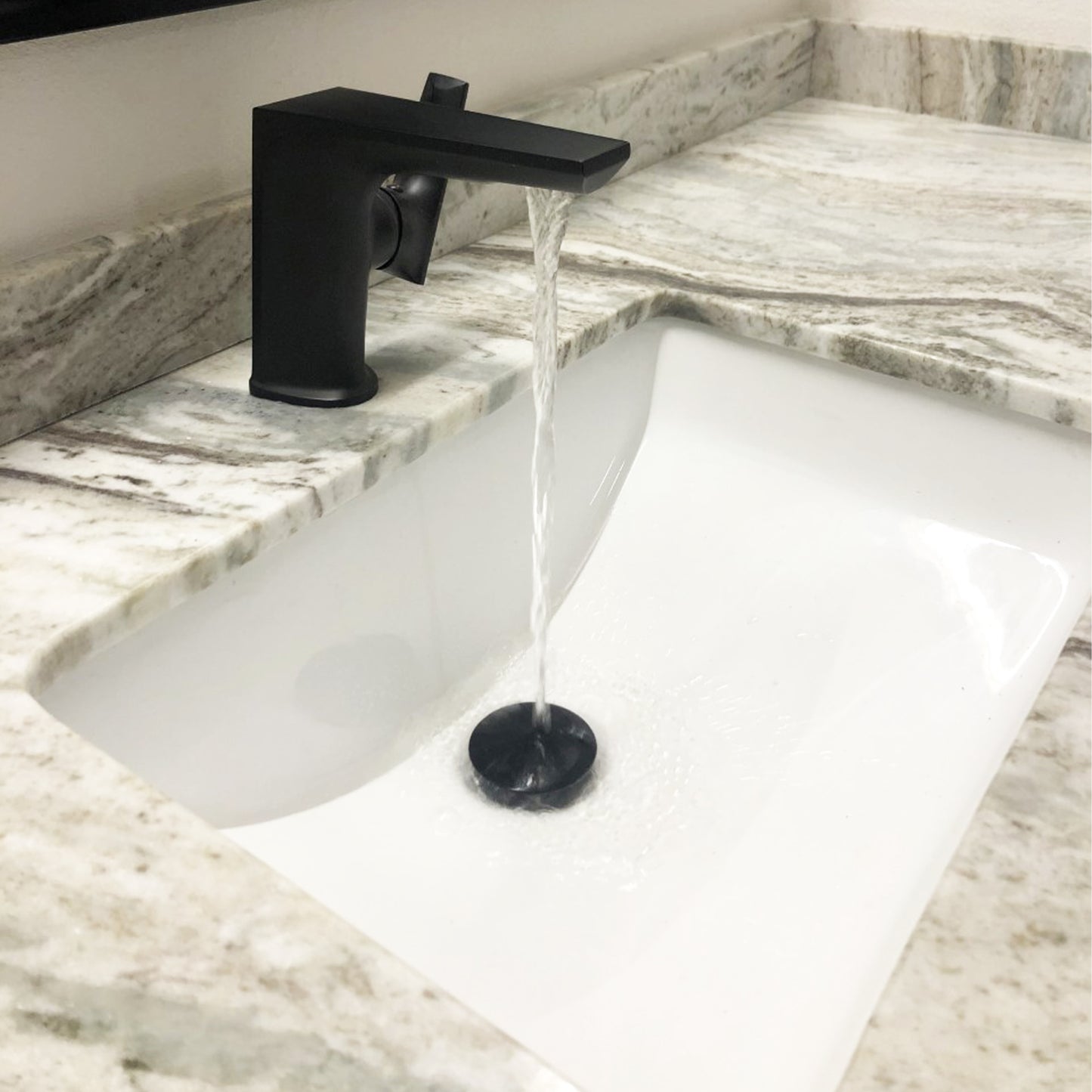 White rectangular undermount porcelain sink with overflow by Novatto, shown installed in a modern bathroom setting.