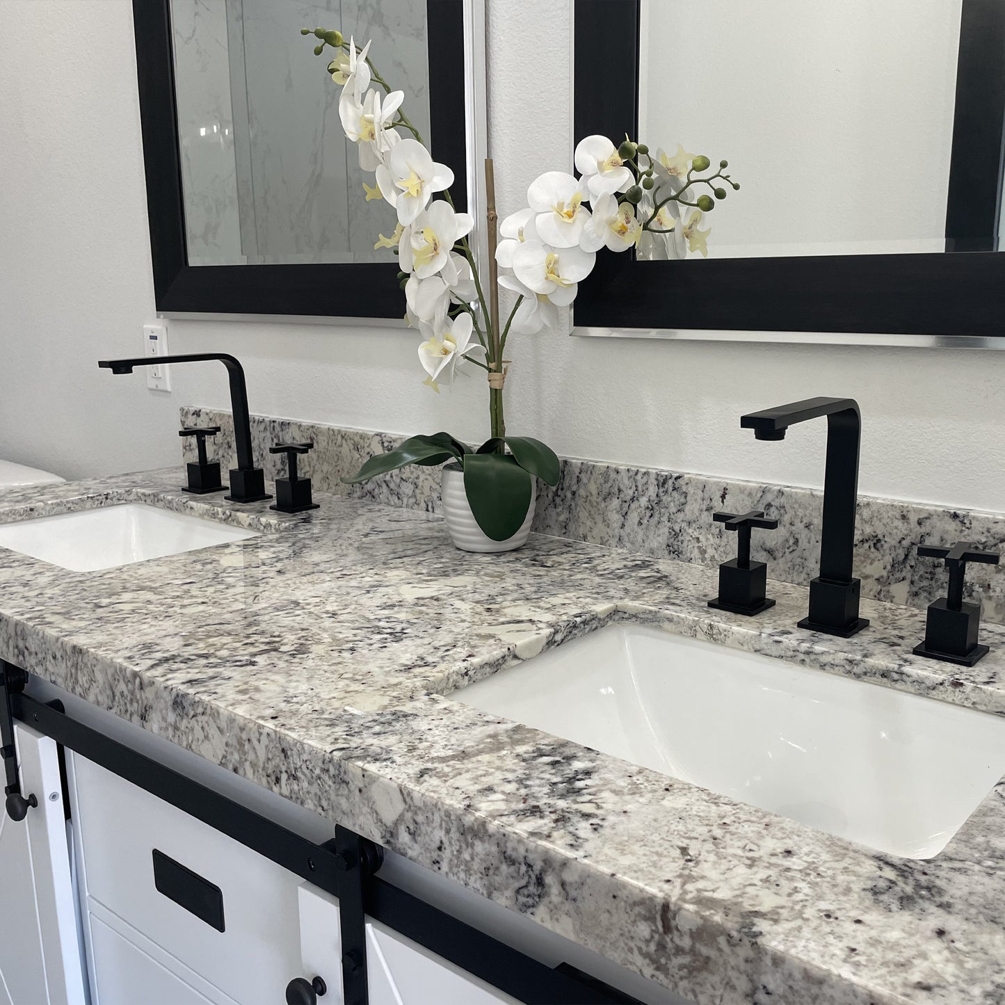 White rectangular undermount porcelain sink with overflow, designed by Novatto, shown installed in a modern kitchen setting.