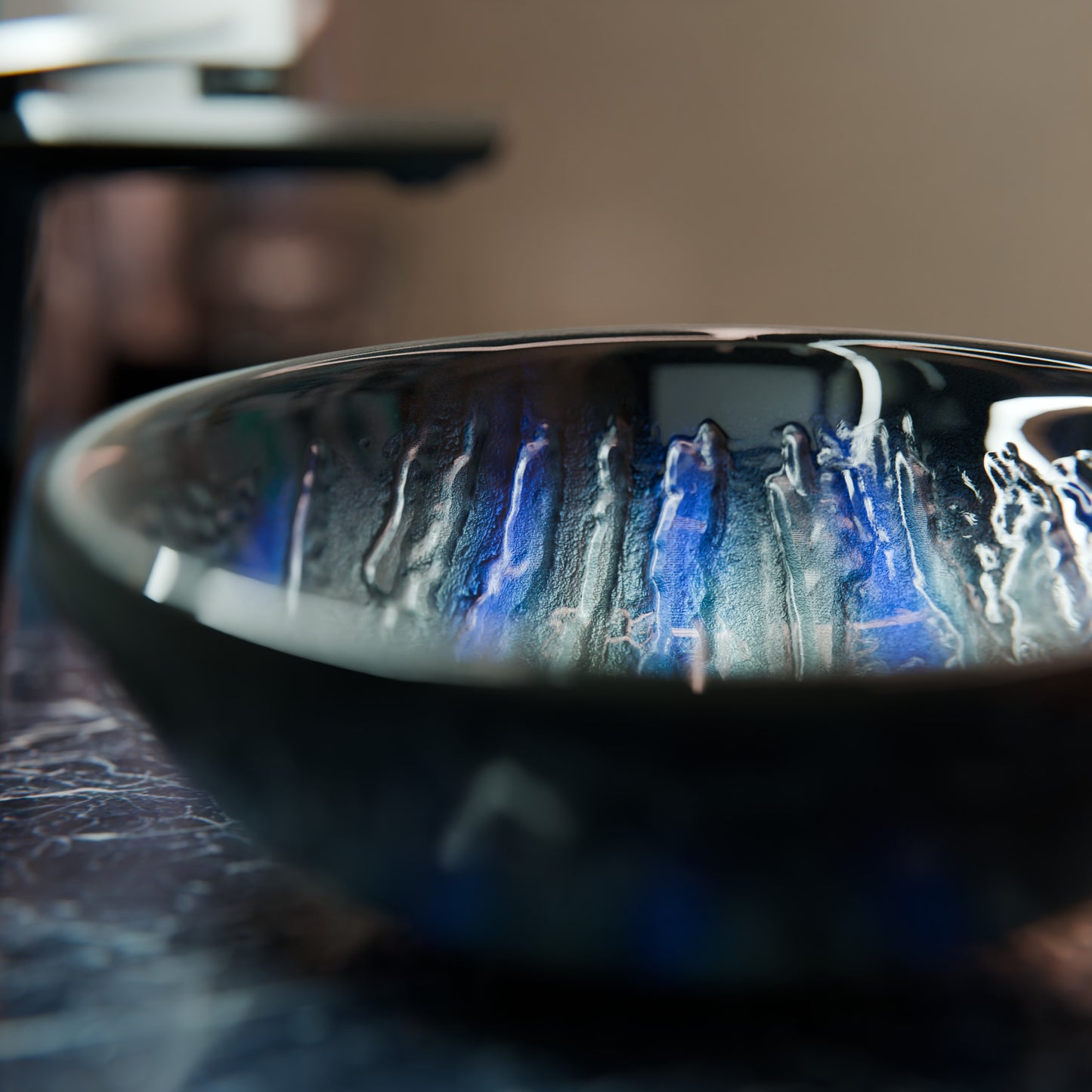 Blue and silver painted glass bathroom vessel sink by Novatto, modern design with smooth, curved shape for contemporary bathrooms.