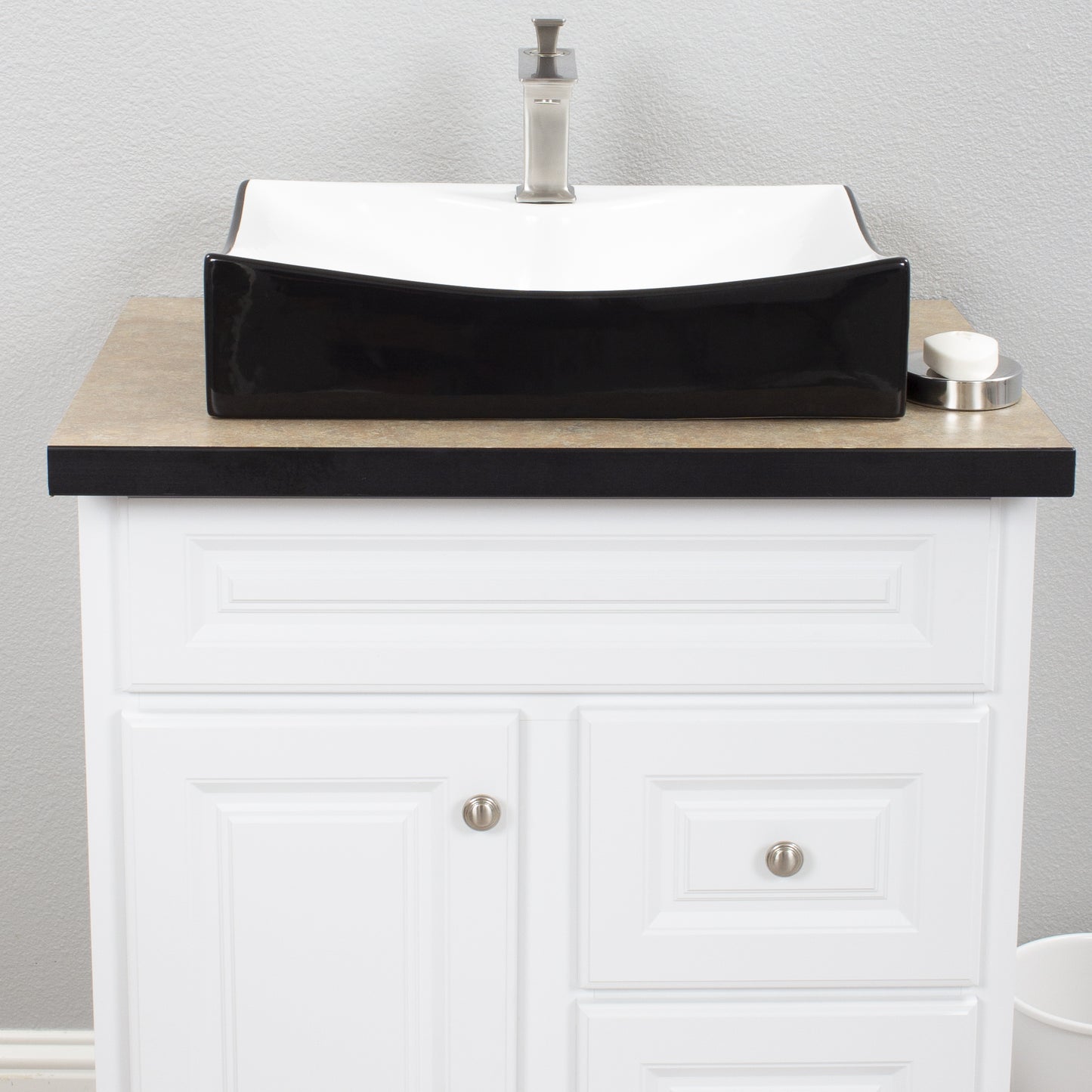 Black and white porcelain vessel sink by Novatto, front view showing sleek design and smooth surface in a modern bathroom setting.
