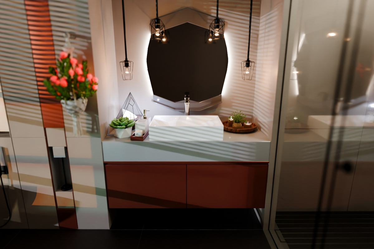 Modern bathroom vanity with mirror and decorative items.