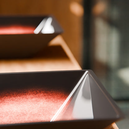 Modern copper and black square glass vessel bathroom sink by Novatto, featuring a sleek design and clear glass surface.