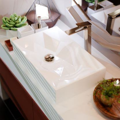 Modern rectangular white porcelain vessel sink by Novatto with geometric design, shown in a neutral setting.