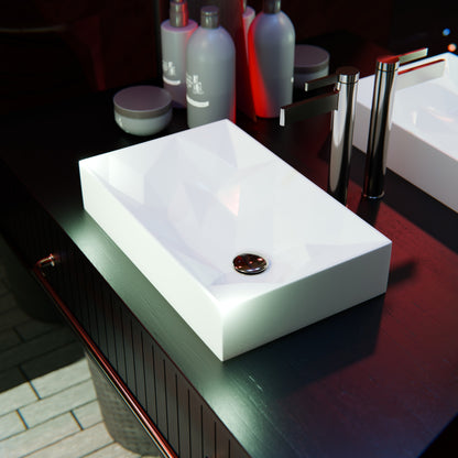 Modern rectangular white porcelain vessel sink with geometric design by Novatto, shown in close-up view.