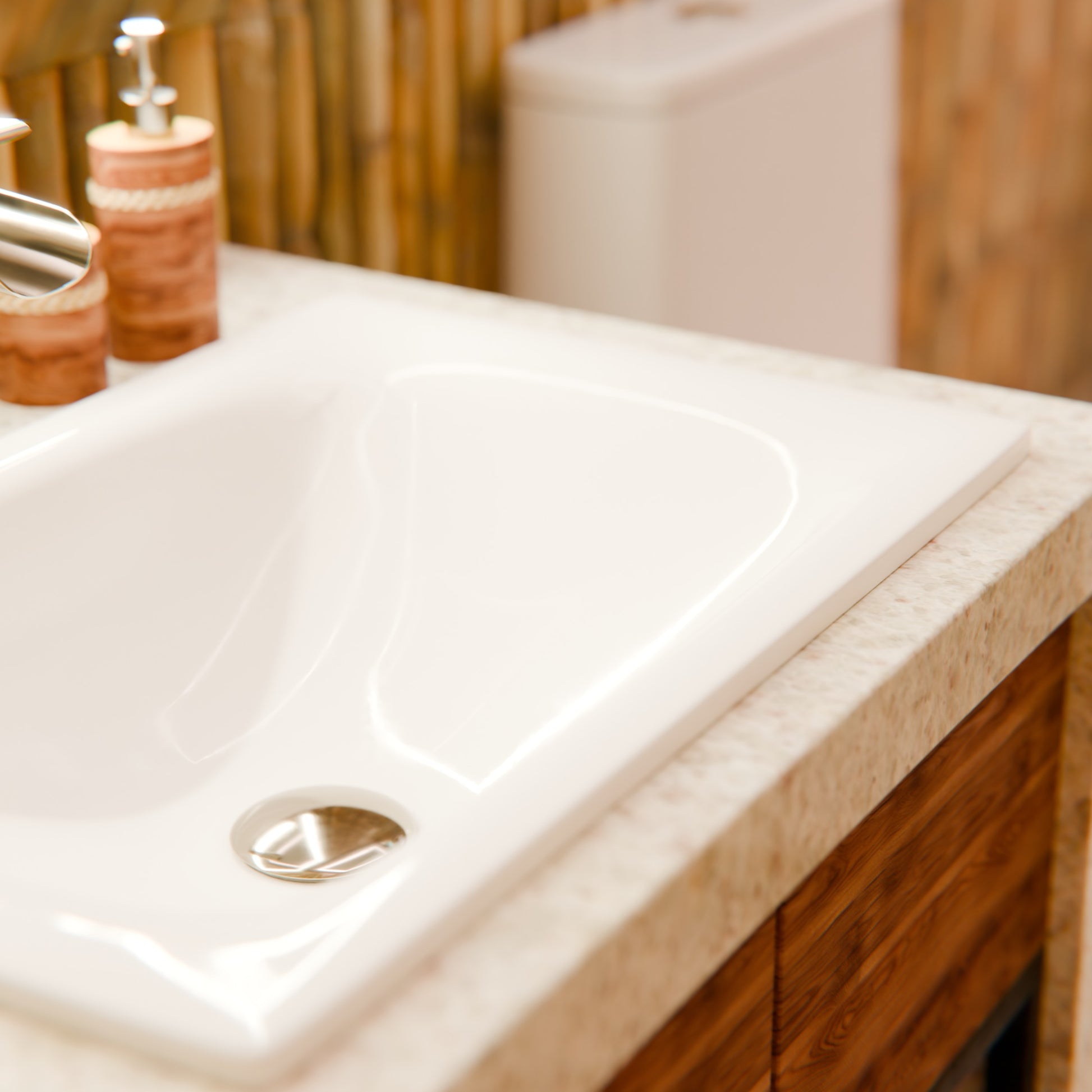 Rectangular white porcelain drop-in bathroom sink by Novatto with a modern contemporary design, shown with a bamboo background.