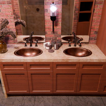 Traditional oval copper drop-in bathroom sink with rolled rim in antique finish by Novatto, shown in a classic bathroom setting