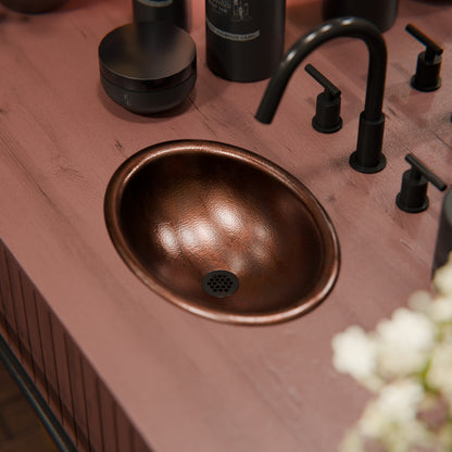 Small oval copper drop-in bath sink by Novatto, antique finish, transitional style, suitable for bathroom vanity.