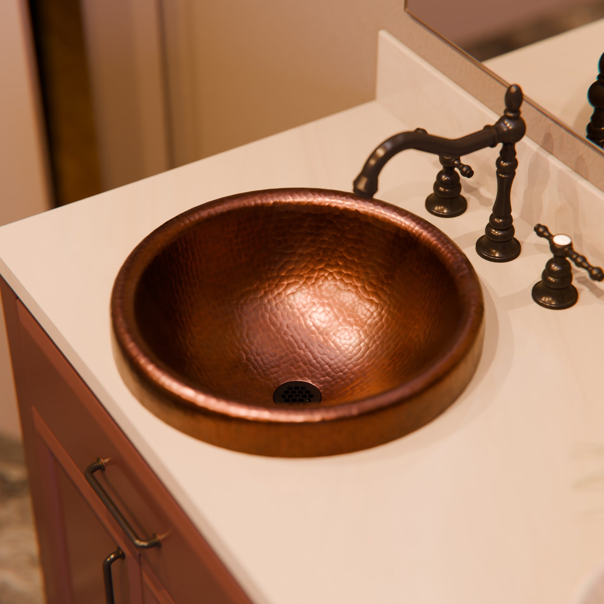 Round copper drop-in bathroom sink in antique finish by Novatto, traditional style with detailed surface texture.