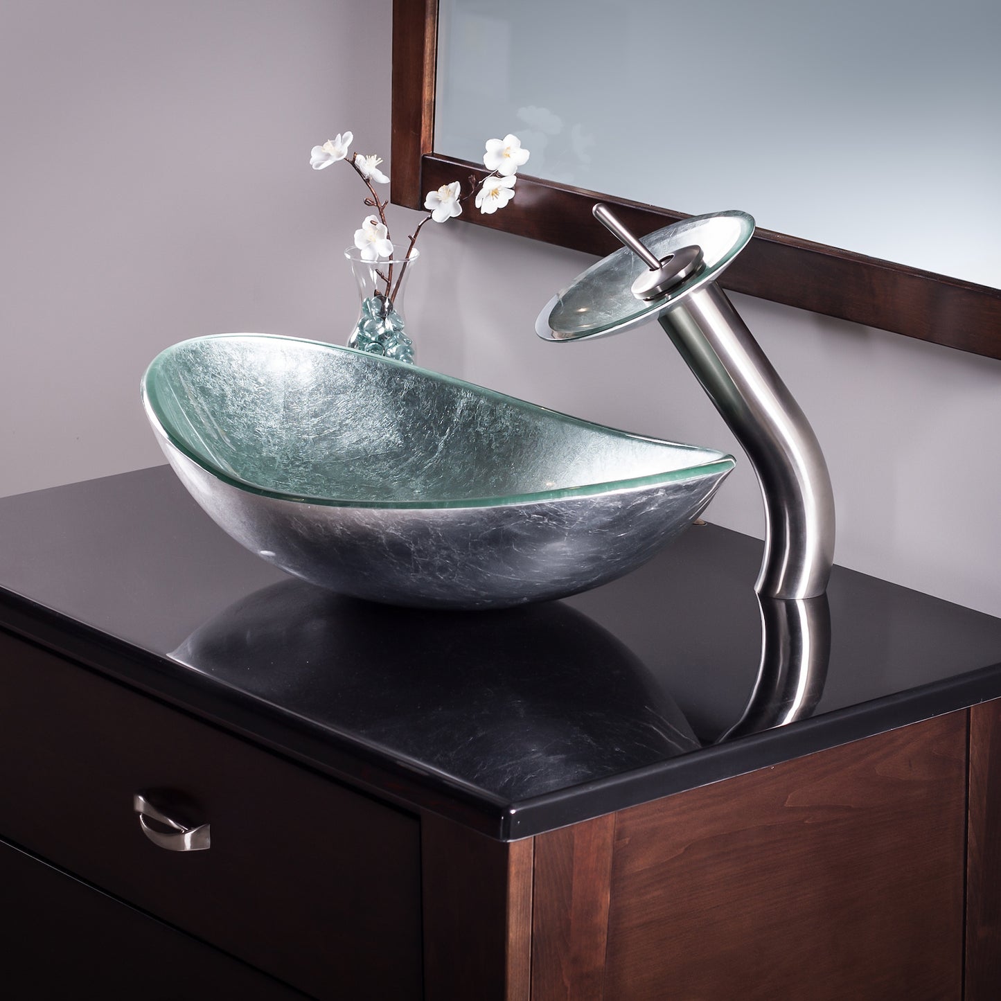 Modern silver foiled oval tempered glass vessel sink by Novatto, shown in a stylish bathroom setting.