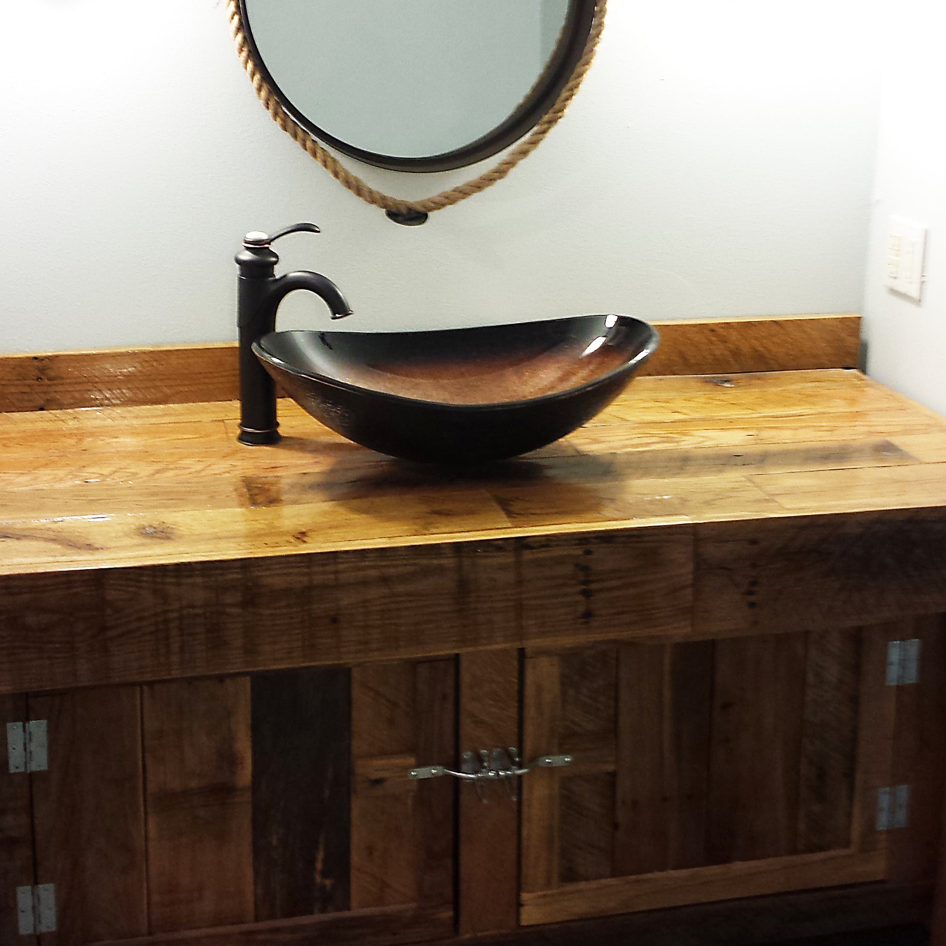 Black and copper oval glass vessel bathroom sink by Novatto, featuring a sleek transitional design with smooth glass surface.