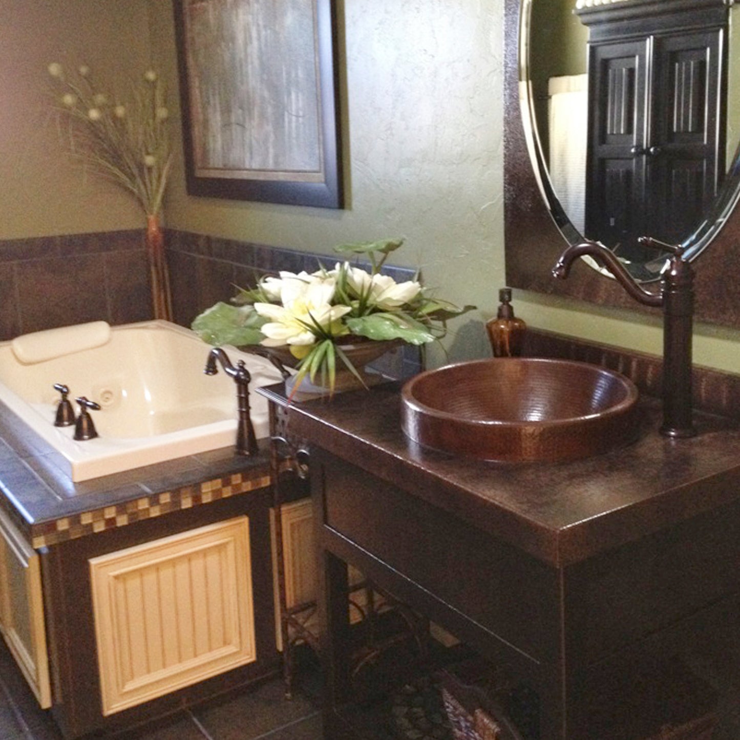 Round copper drop-in bathroom sink by Novatto with antique finish, traditional style, shown installed in a bathroom setting