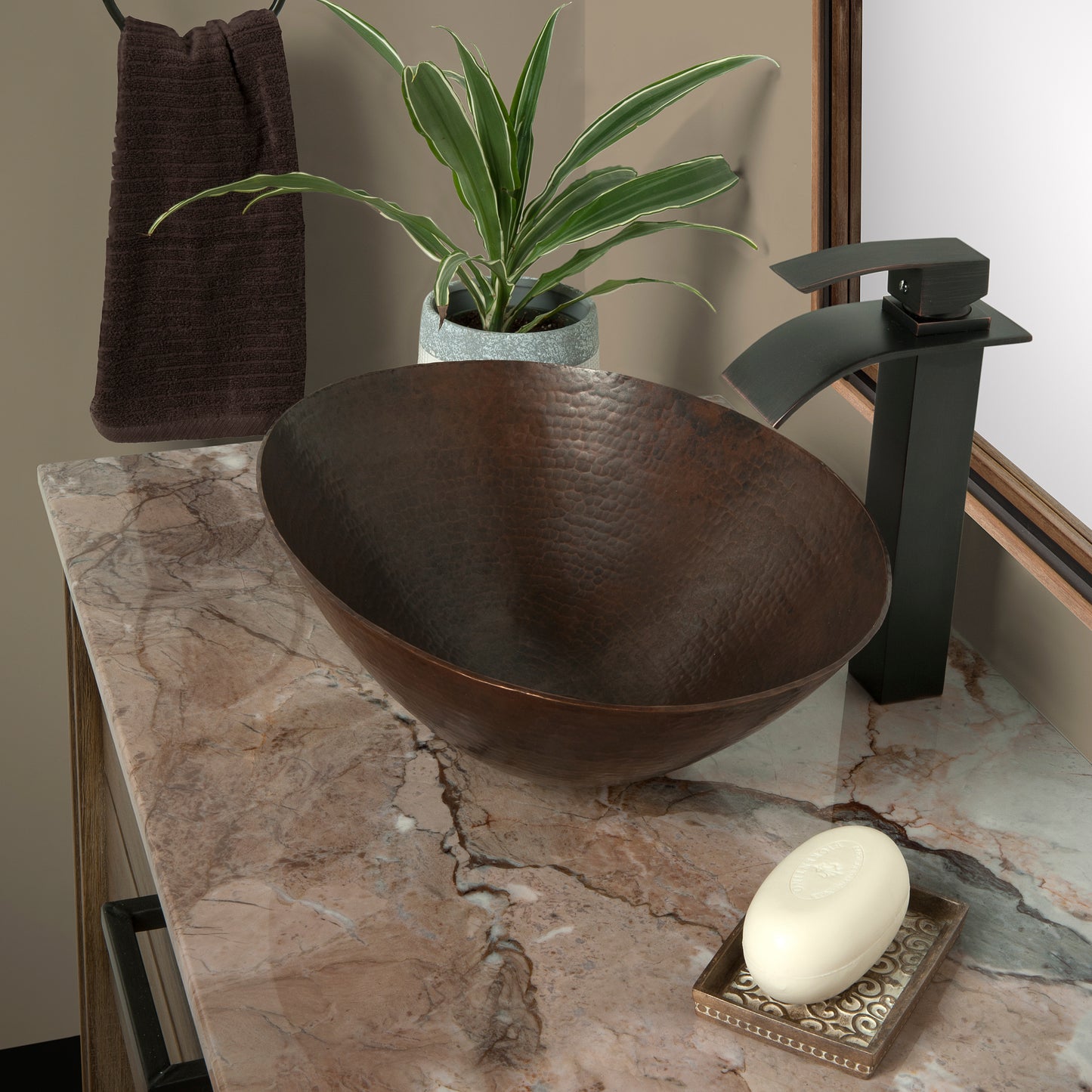 Oval hammered copper vessel bathroom sink in antique finish by Novatto, showcasing a traditional design with a smooth, rounded shape.