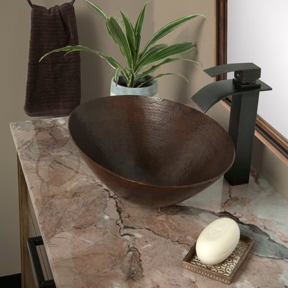 Oval hammered copper vessel bathroom sink in antique finish by Novatto, showcasing a traditional design with a smooth, rounded shape.